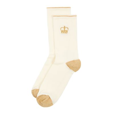 A pair of cream ankle socks with gold contrasting heel and toe sections. The outer ankle section features an embroidered gold royal crown. 