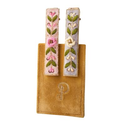 Two fabric-covered thin, rectangular hair clips with embroidered flowers and vines on them. One clip has a blue background and the other is pink.