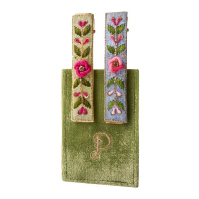 Two fabric-covered thin, rectangular hair clips with embroidered flowers and vines on them. One clip has a blue background and the other is light-green.