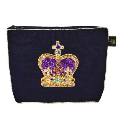 A dark navy velvet purse with a gold and purple embellished crown embroidered on one side. With a zip top closure. 