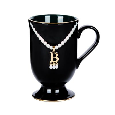 Black mug with gold and pearl 'B' pendant necklace
