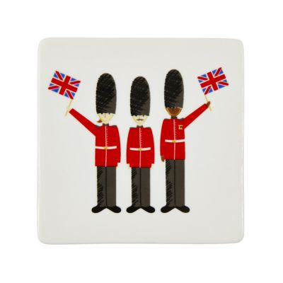 White coaster with three British guards waving the Union Jack flag