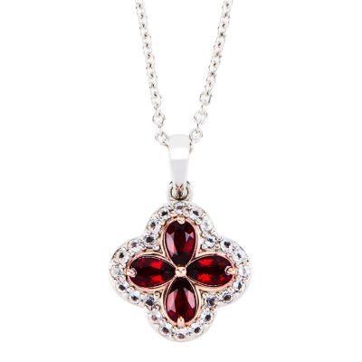 A quatrefoil shaped pendant with four pear-cut red garnet stones surrounded by small white topaz stones. Hung on a sterling silver chain. 