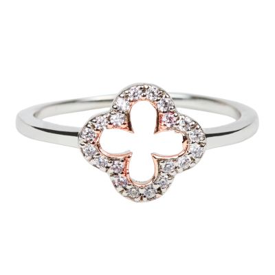 A silver ring with a quatrefoil-shaped pendant inlaid with white topaz stones with rose-gold plated detailing. 