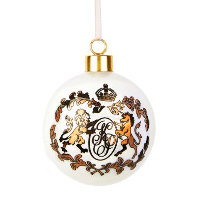 A white bauble with a gold crest from Kensington Palace printed on one side. The crest includes ornate K and P letters alongside a lion and a unicorn motif. 
