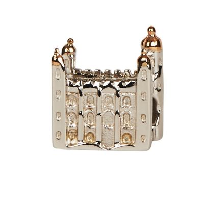 A silver charm bead in the shape of the White Tower at the Tower of London with delicate window details. The turrets are made from rose gold. 