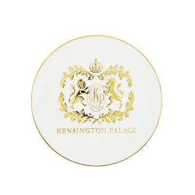 White round coaster with gold edge and crest of Kensington Palace