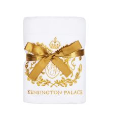 A white hand towel wrapped in a gold ribbon with an embroidered gold Kensington Palace crest.