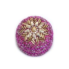 A small pink beaded trinket tin with a gold flower design on the lid. 