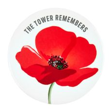 A white ceramic coaster with a printed design of a red poppy with a green stalk. Text above it reads, The Tower Remembers.