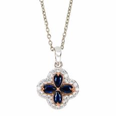 A silver pendant necklace in a quatrefoil shape with four deep-blue cubic zirconia and surrounded by white topaz stones. 