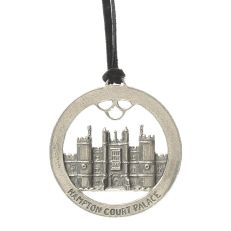 A round, metal hanging decoration with Hampton Court Palace in the centre 