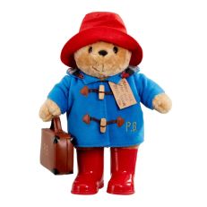 A Paddington Bear soft teddy wearing a red hat, blue duffle coat, red wellington boots and carrying a brown suitcase.