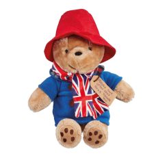 A Paddington Bear soft toy wearing a red hat and blue duffle coat with a union jack patterned scarf around his neck. 