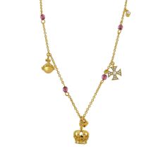 A gold necklace with a crown pendant and mini gold charms hanging from the chain. 