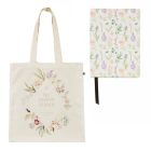 A cotton tote bag with a floral print in a diamond shape with the words, The Sunken Garden at Kensington Palace, alongside a matching floral notebook. 
