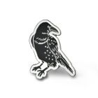 A black metal enamelled pin badge in the shape of a raven. 