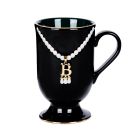 Black mug with gold and pearl 'B' pendant necklace