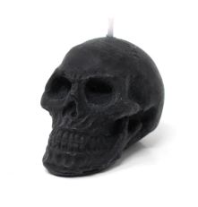 Small black wax candle in the shape of a skull